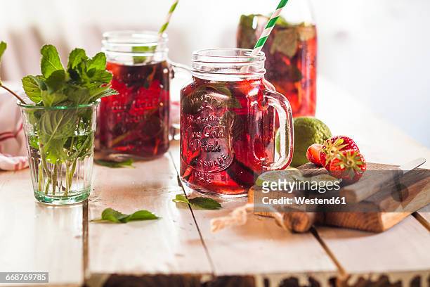 iced tea with fruits, hibiscus, strawberries, mint, limes - ice tea stock-fotos und bilder