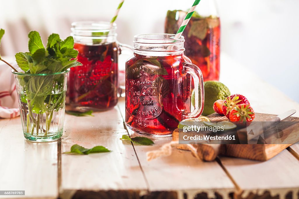 Iced tea with fruits, hibiscus, strawberries, mint, limes