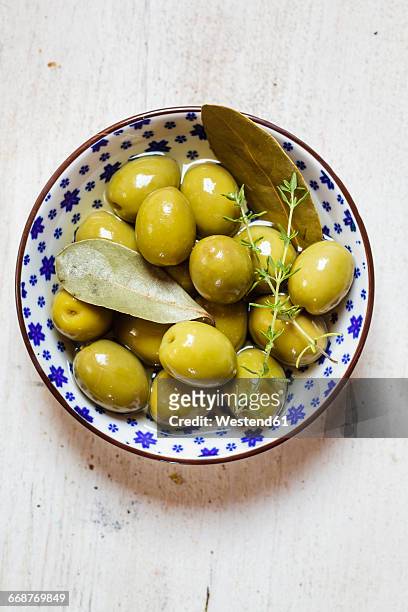 green olives in bowl with thyme and bay leaf - olive 個照片及圖片檔