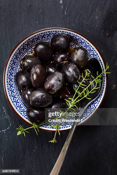 black olives in bowl with thyme - black olive stockfoto's en -beelden