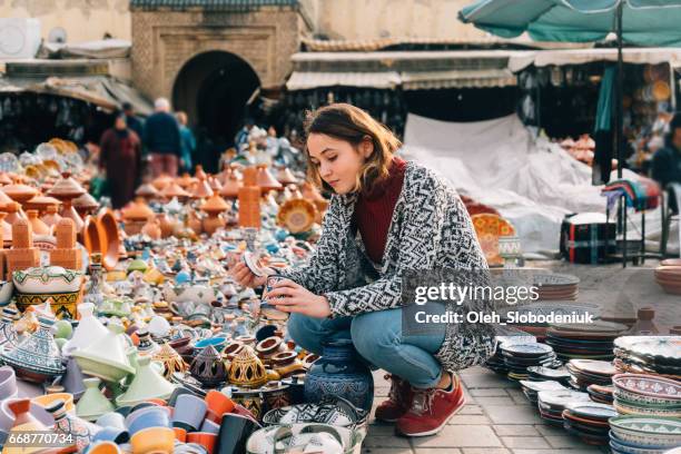 kvinnan att välja keramik i butik i meknès, marocko - meknes bildbanksfoton och bilder