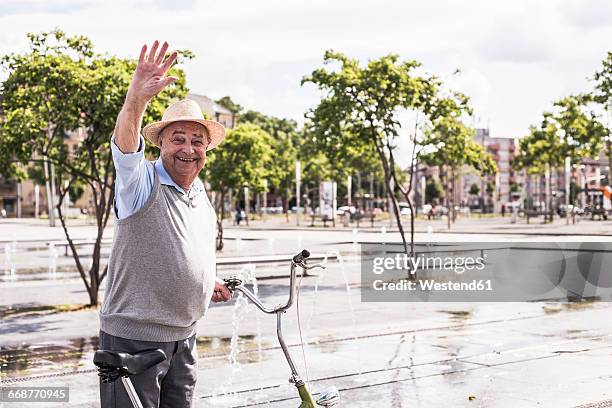 portrait of waving senior man with folding bicycle - wave hello outside stock pictures, royalty-free photos & images