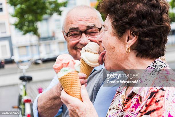senior couple enjoy eating ice cream together - ice cream stockfoto's en -beelden