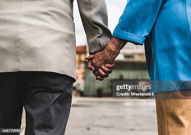 back view of senior couple holding hands, close-up - holding hands close up stock-fotos und bilder