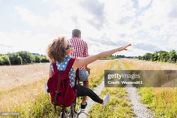 happy young couple on a bicycle tour - landweg stock-fotos und bilder