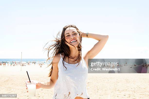 young woman drinking cocktail on the beach - young woman beach smiling stock pictures, royalty-free photos & images