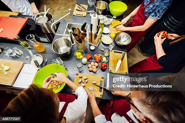 members of a cooking class preparing food - cookery class stock-fotos und bilder