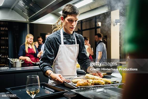 young chef with hot food in a cooking class - young chefs cooking stock pictures, royalty-free photos & images