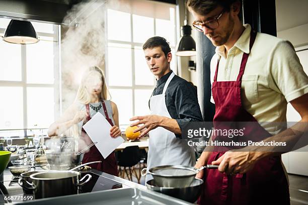 chef assisting members of a cooking class - cookery class stock-fotos und bilder
