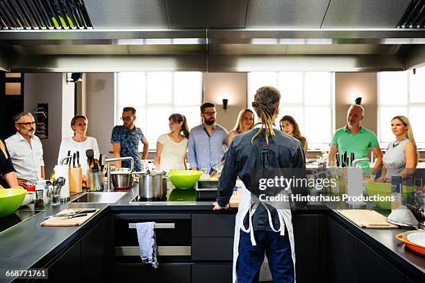 young chef welcoming his cooking class - 料理教室 ストックフォトと画像