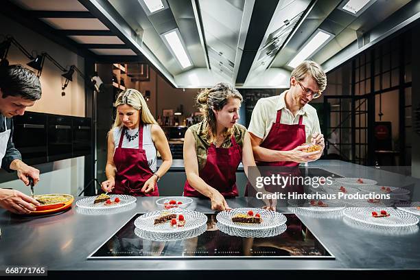 cooking class members preparing dessert - cooking class stockfoto's en -beelden