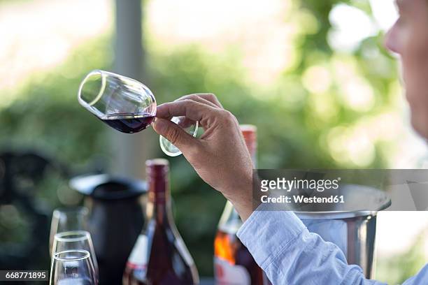 man holding and judging glass of red wine - wijn proeven stockfoto's en -beelden