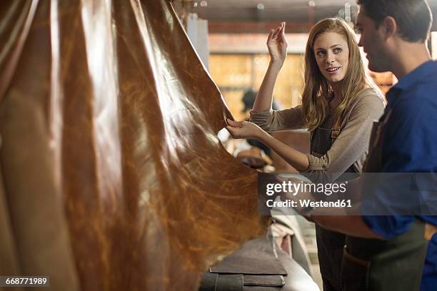 man and woman working in leather workshop - leather industry stock pictures, royalty-free photos & images