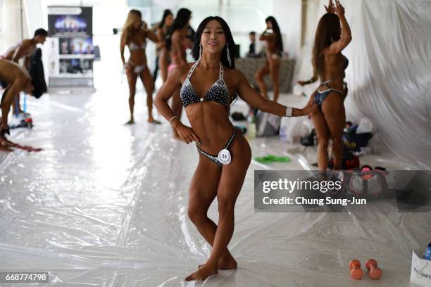 Female bodybuilders prepare themselves for judging backstage during the 2017 NABBA WFF Asia Seoul Open Championship on April 15, 2017 in Seoul, South...