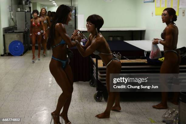 Female bodybuilders prepare themselves for judging backstage during the 2017 NABBA WFF Asia Seoul Open Championship on April 15, 2017 in Seoul, South...