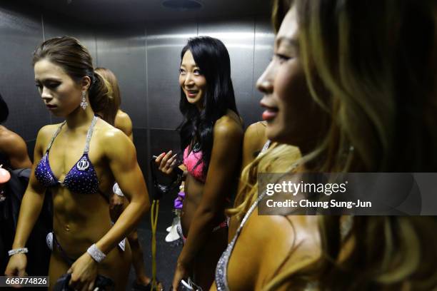 Female bodybuilders prepare themselves for judging backstage during the 2017 NABBA WFF Asia Seoul Open Championship on April 15, 2017 in Seoul, South...