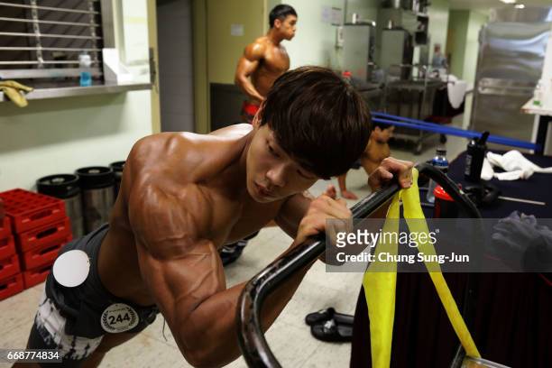 Bodybuilders prepare themselves for judging backstage during the 2017 NABBA WFF Asia Seoul Open Championship on April 15, 2017 in Seoul, South Korea.