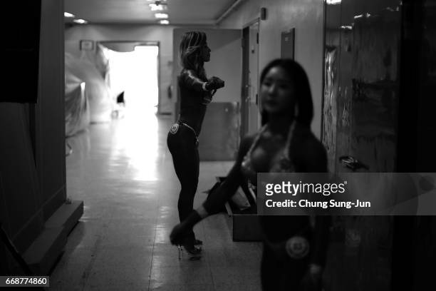 Female bodybuilders prepare themselves for judging backstage during the 2017 NABBA WFF Asia Seoul Open Championship on April 15, 2017 in Seoul, South...