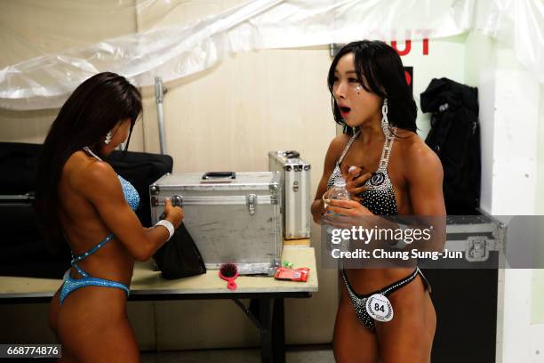 Female bodybuilders prepare themselves for judging backstage during the 2017 NABBA WFF Asia Seoul Open Championship on April 15, 2017 in Seoul, South...