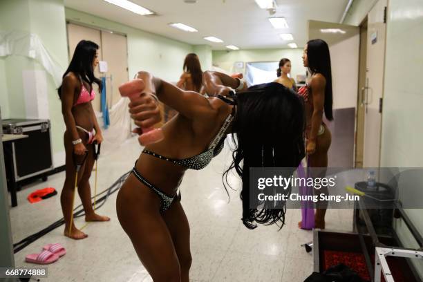 Female bodybuilders prepare themselves for judging backstage during the 2017 NABBA WFF Asia Seoul Open Championship on April 15, 2017 in Seoul, South...