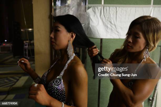 Female bodybuilders prepare themselves for judging backstage during the 2017 NABBA WFF Asia Seoul Open Championship on April 15, 2017 in Seoul, South...