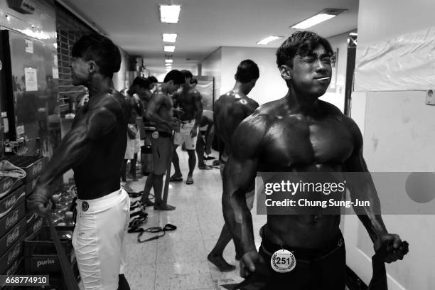 Bodybuilders prepare themselves for judging backstage during the 2017 NABBA WFF Asia Seoul Open Championship on April 15, 2017 in Seoul, South Korea.