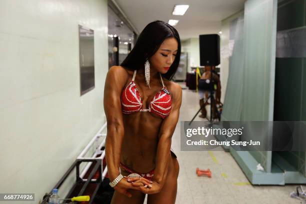 Female bodybuilder prepares herself for judging backstage during the 2017 NABBA WFF Asia Seoul Open Championship on April 15, 2017 in Seoul, South...