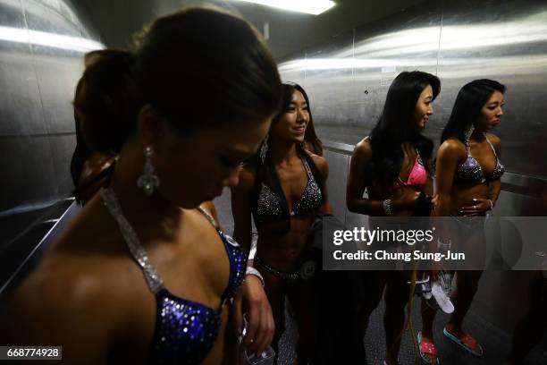 Female bodybuilders prepare themselves for judging backstage during the 2017 NABBA WFF Asia Seoul Open Championship on April 15, 2017 in Seoul, South...