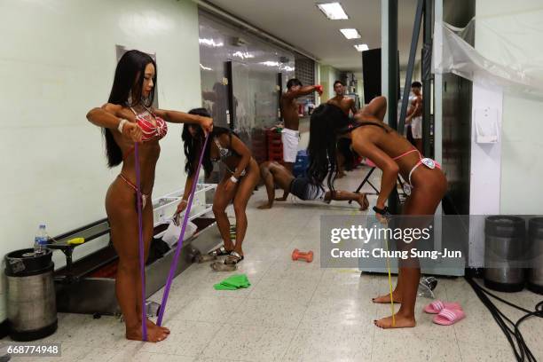 Female bodybuilders prepare themselves for judging backstage during the 2017 NABBA WFF Asia Seoul Open Championship on April 15, 2017 in Seoul, South...