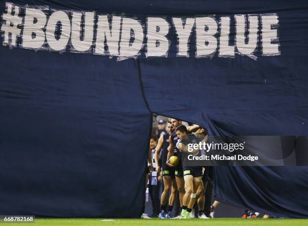 Marc Murphy of the Bluesleads the team out through the banner during the round four AFL match between the Carlton Blues and the Gold Coast Suns at...