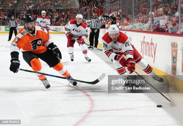 Bryan Bickell of the Carolina Hurricanes skates the puck along the boards against Andrew MacDonald of the Philadelphia Flyers on April 9, 2017 at the...