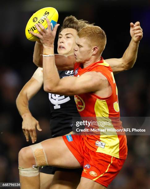 Peter Wright of the Suns and Caleb Marchbank of the Blues compete for the ball during the 2017 AFL round 04 match between the Carlton Blues and the...