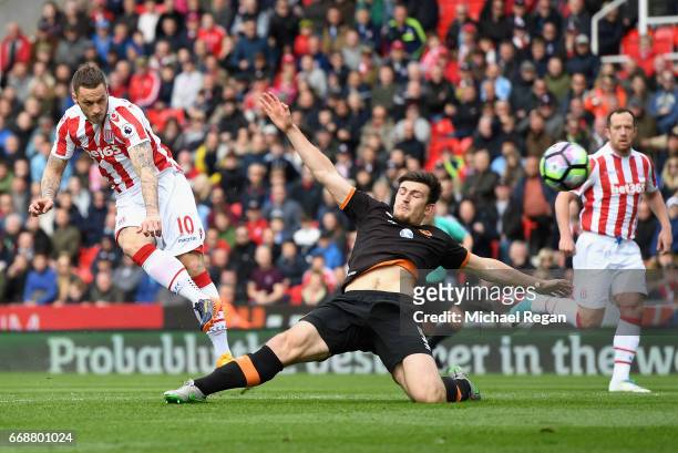 Marko Arnautovic of Stoke City scores his sides first goal as Harry Maguire of Hull City attempts to block during the Premier League match between...