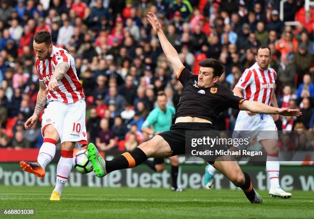 Marko Arnautovic of Stoke City scores his sides first goal as Harry Maguire of Hull City attempts to block during the Premier League match between...