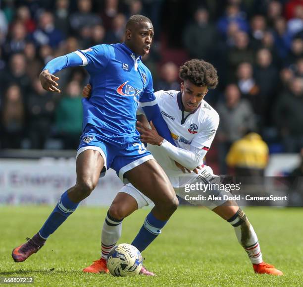 Oldham Athletic's Ousmane Fane holds off the challenge from Bolton Wanderers' Derik Osede during the Sky Bet League One match between Oldham Athletic...