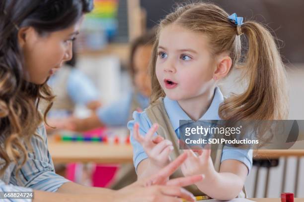 teacher helps young student with math - mathematical symbol stock pictures, royalty-free photos & images