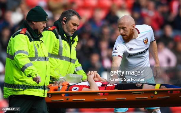 James Collins of West Ham United stands over Billy Jones of Sunderland as he is stretchered off through injury during the Premier League match...