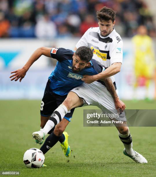 Kerem Demirbay of 1899 Hoffenheim is challenged by Tobias Strobl of Borussia Moenchengladbach during the Bundesliga match between TSG 1899 Hoffenheim...