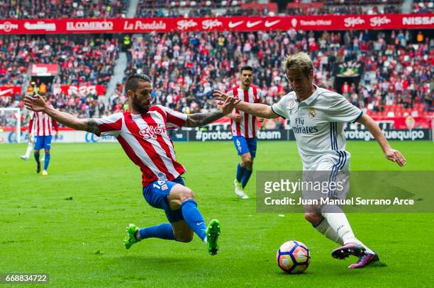 Fabio Coentrao of Real Madrid duels for the ball with Manuel Castellano 'Lillo' of Real Sporting de Gijon during the La Liga match between Real...
