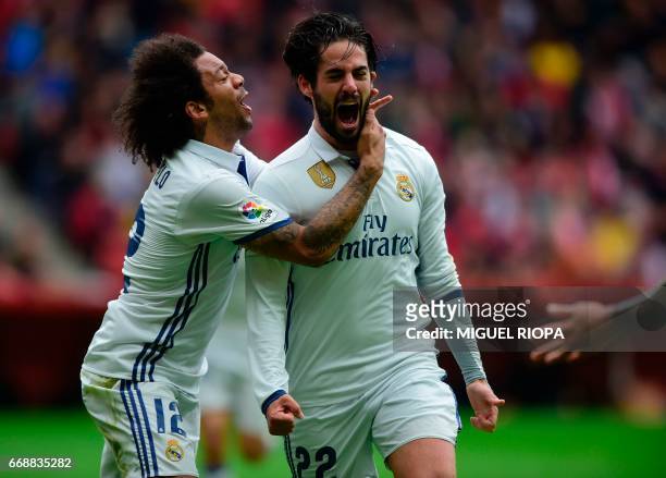 Real Madrid's midfielder Isco celebrates with teammate Brazilian defender Marcelo after scoring a goal during the Spanish league football match Real...