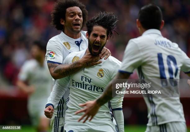 Real Madrid's midfielder Isco celebrates with teammate Brazilian defender Marcelo after scoring a goal during the Spanish league football match Real...