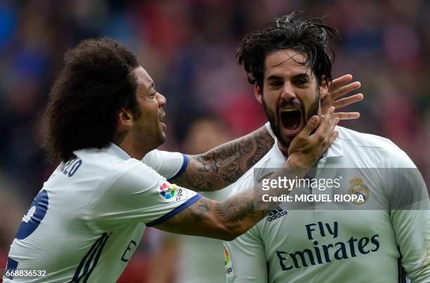 Real Madrid's midfielder Isco celebrates with teammate Brazilian defender Marcelo after scoring a goal during the Spanish league football match Real...