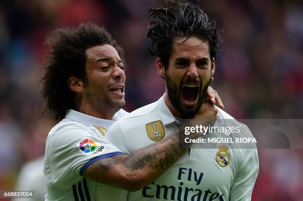 Real Madrid's midfielder Isco is congratulated by teammate Brazilian defender Marcelo after scoring a goal during the Spanish league football match...