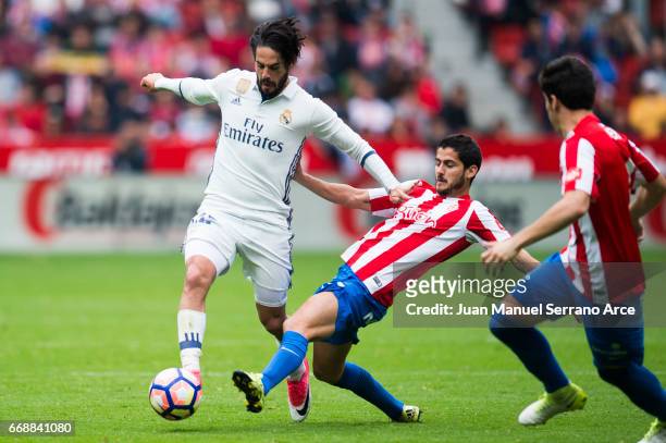 Isco of Real Madrid duels for the ball with Nacho Cases of Real Sporting de Gijon during the La Liga match between Real Sporting de Gijon and Real...