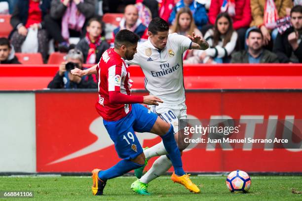James Rodriguez of Real Madrid duels for the ball with Carlos Carmona of Real Sporting de Gijon during the La Liga match between Real Sporting de...