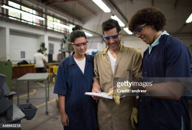 engineering students in a workshop talking to their teacher - industrial designer stock pictures, royalty-free photos & images