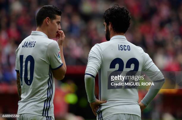 Real Madrid's Colombian midfielder James Rodriguez speaks with midfielder Isco during the Spanish league football match Real Sporting de Gijon vs...