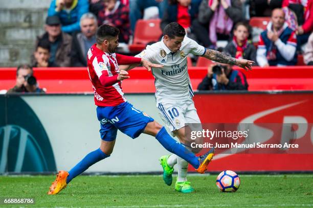 James Rodriguez of Real Madrid duels for the ball with Carlos Carmona of Real Sporting de Gijon during the La Liga match between Real Sporting de...
