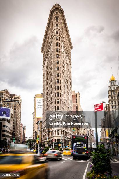 the flat iron cars and taxis in blurred motion - flatiron building stockfoto's en -beelden