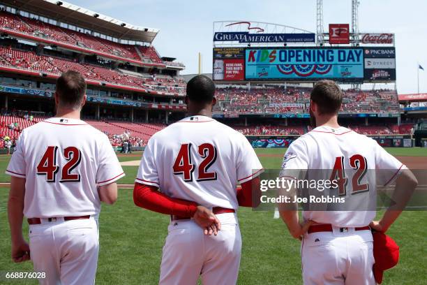 Cincinnati Reds players wear No. 42 in honor of Jackie Robinson Day as they stand for the national anthem prior to a game against the Milwaukee...